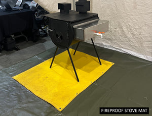 Fireproof stove mat under a black canvas tent stove with water tank inside a wall tent setup on a protective gray floor surface.