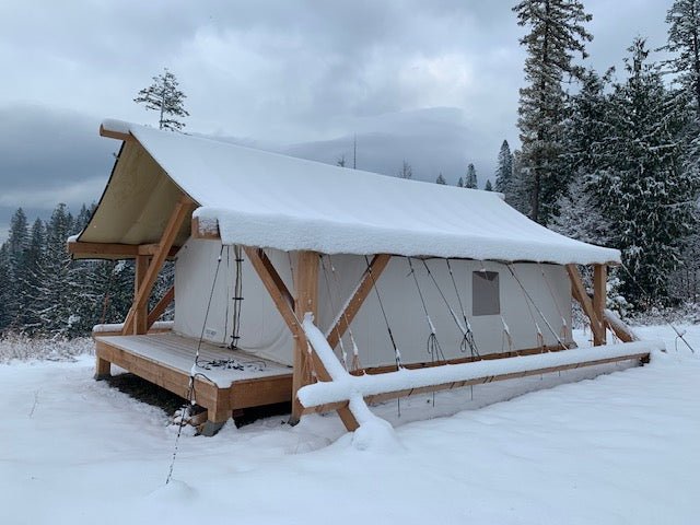 Heavy Duty Canvas Tent with snow-covered roof in a snowy forest