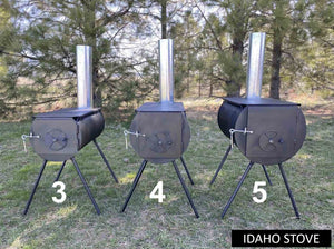 Three black Idaho camp stoves with stovepipes and angled legs displayed outdoors on grass, labeled sizes 3, 4, and 5.