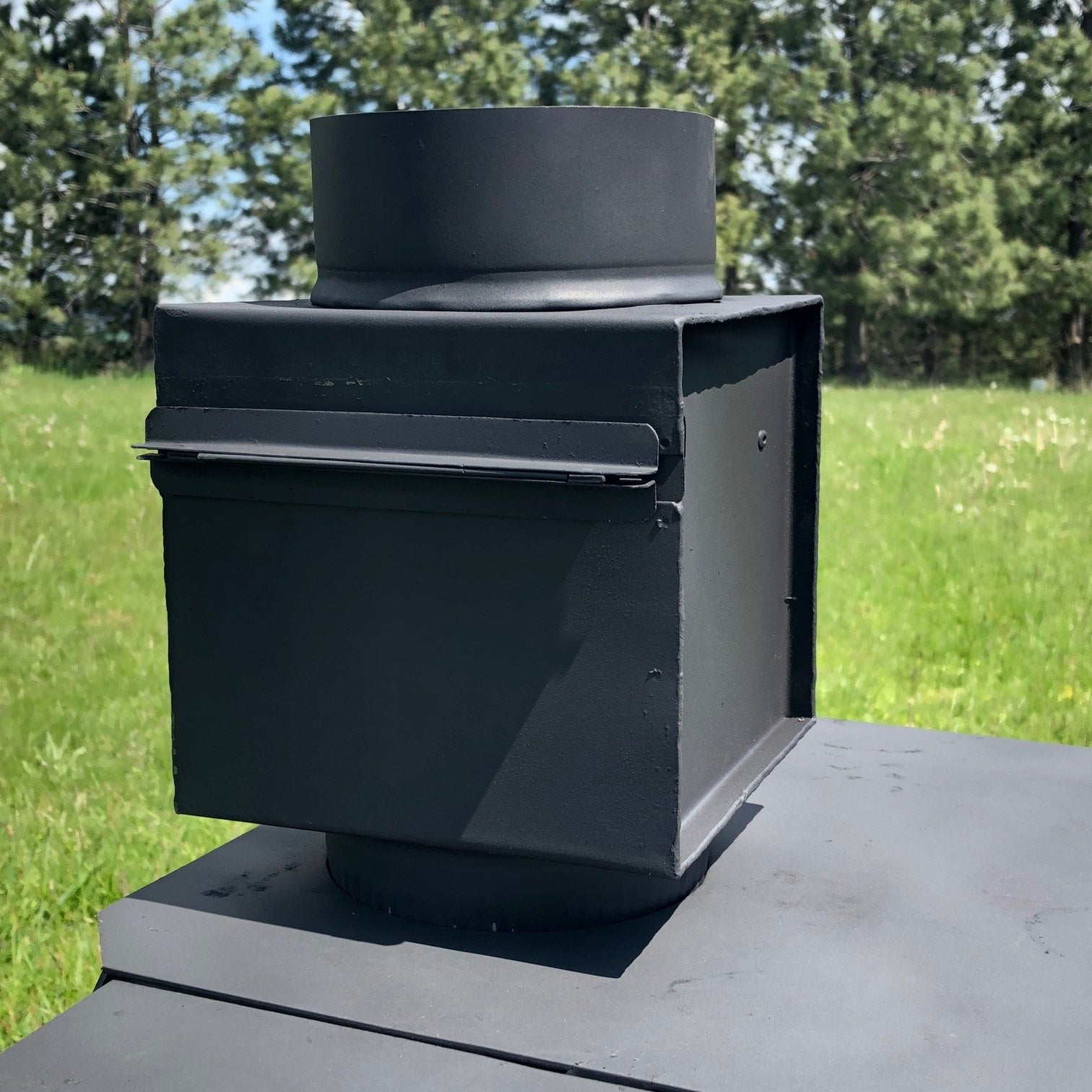 5" In-Iine spark arrestor, stack robber, heat exchanger, black sheet metal box used in canvas tent camping to catch sparks as they exit the wood stove pipe.  Useful with canvas tents, wall tents, hunting tents, and glamping tents.